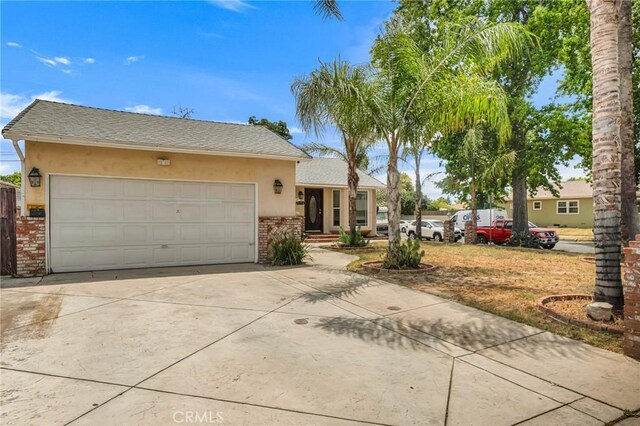 20554 Valerio St, Winnetka, CA 91306 - ranch-style house with stucco siding, driveway, brick siding, an attached garage, and roof with shingles