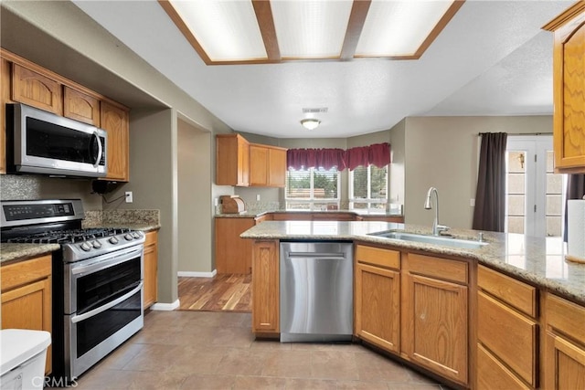 9275 Verdugo Ave, Hesperia, CA 92345 - kitchen featuring appliances with stainless steel finishes, a sink, light stone countertops, and light tile patterned floors
