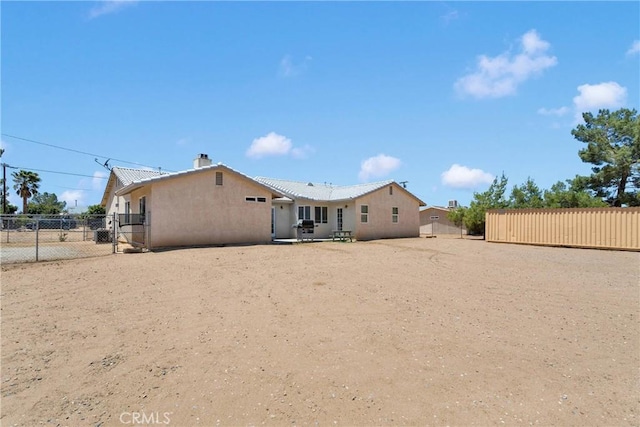 9275 Verdugo Ave, Hesperia, CA 92345 - back of property with stucco siding, a chimney, and a gate