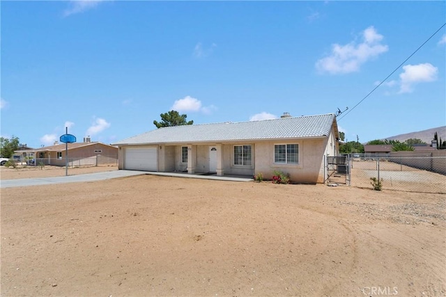 9275 Verdugo Ave, Hesperia, CA 92345 - view of front of house featuring an attached garage, concrete driveway, a gate, stucco siding, and a tile roof