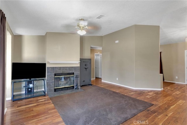 9275 Verdugo Ave, Hesperia, CA 92345 - unfurnished living room featuring ceiling fan, wood finished floors, baseboards, and a tile fireplace