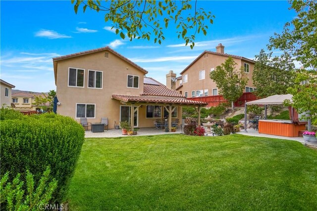 17334 Sierra Sunrise Ln, Canyon Country, CA 91387 - rear view of house featuring a patio area, a hot tub, stucco siding, and a tiled roof