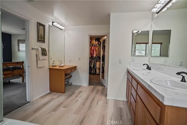 17334 Sierra Sunrise Ln, Canyon Country, CA 91387 - bathroom with wood finished floors, double vanity, baseboards, and a spacious closet