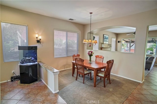 17334 Sierra Sunrise Ln, Canyon Country, CA 91387 - dining area featuring arched walkways, a chandelier, tile patterned floors, and baseboards