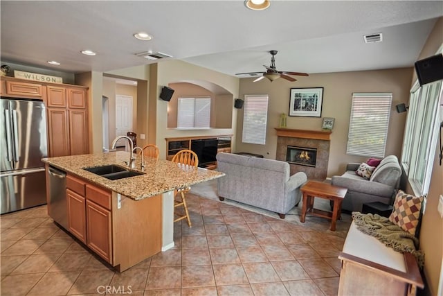 17334 Sierra Sunrise Ln, Canyon Country, CA 91387 - kitchen with stainless steel appliances, a fireplace, a sink, ceiling fan, and open floor plan