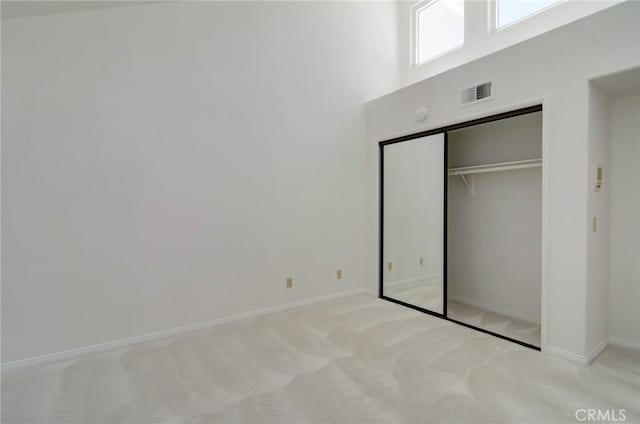6052 Shadowbrook Cir, Huntington Beach, CA 92648 - unfurnished bedroom featuring carpet flooring, baseboards, a closet, and a towering ceiling