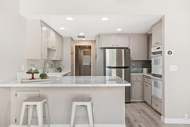 3404 Oak Cliff Dr Unit 2, Fallbrook, CA 92028 - kitchen featuring freestanding refrigerator, a peninsula, a sink, light countertops, and double oven
