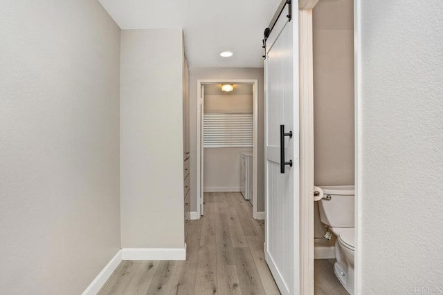 3404 Oak Cliff Dr Unit 2, Fallbrook, CA 92028 - hallway featuring a barn door, light wood finished floors, and baseboards
