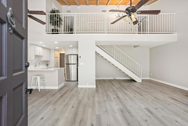 3404 Oak Cliff Dr Unit 2, Fallbrook, CA 92028 - unfurnished living room featuring a ceiling fan, a high ceiling, light wood-type flooring, a sink, and baseboards