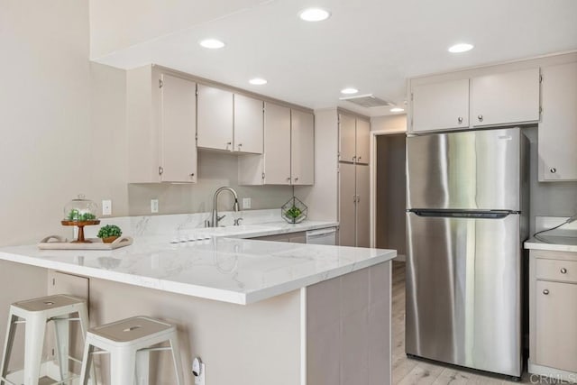 3404 Oak Cliff Dr Unit 2, Fallbrook, CA 92028 - kitchen with freestanding refrigerator, a sink, a peninsula, recessed lighting, and light stone countertops