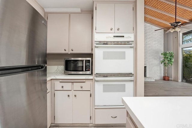 3404 Oak Cliff Dr Unit 2, Fallbrook, CA 92028 - kitchen featuring appliances with stainless steel finishes, light countertops, ceiling fan, wood finished floors, and brick wall