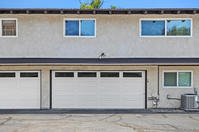 3404 Oak Cliff Dr Unit 2, Fallbrook, CA 92028 - back of property featuring central air condition unit, stucco siding, and a garage