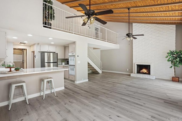 3404 Oak Cliff Dr Unit 2, Fallbrook, CA 92028 - living room with a ceiling fan, high vaulted ceiling, stairs, baseboards, and a fireplace