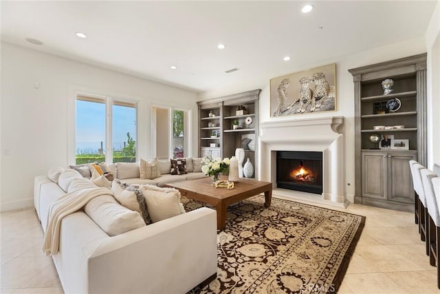 12 Via Avoria, Newport Coast, CA 92657 - living area with a warm lit fireplace, light tile patterned floors, recessed lighting, built in shelves, and baseboards