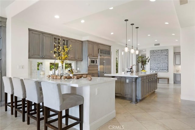 12 Via Avoria, Newport Coast, CA 92657 - kitchen featuring built in appliances, a peninsula, light countertops, light tile patterned floors, and recessed lighting