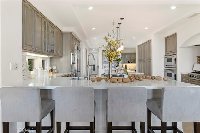 12 Via Avoria, Newport Coast, CA 92657 - kitchen featuring recessed lighting, light countertops, a peninsula, glass insert cabinets, and double oven