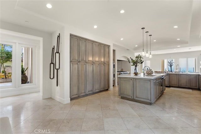 12 Via Avoria, Newport Coast, CA 92657 - kitchen with arched walkways, recessed lighting, a sink, light countertops, and light tile patterned flooring