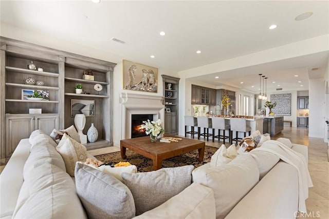 12 Via Avoria, Newport Coast, CA 92657 - living area featuring recessed lighting, a warm lit fireplace, and built in shelves