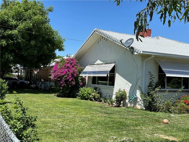 159 S Shasta St S, Willows, CA 95988 - view of home's exterior featuring a yard, stucco siding, and a chimney