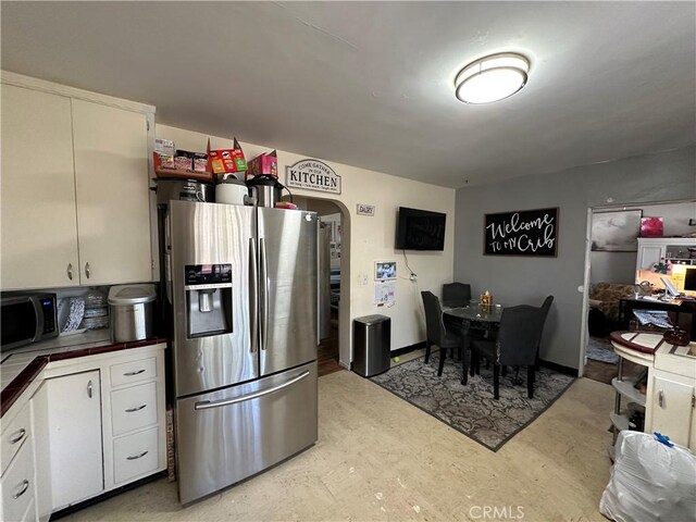 159 S Shasta St S, Willows, CA 95988 - kitchen featuring stainless steel refrigerator with ice dispenser, black microwave, white cabinets, dark countertops, and arched walkways