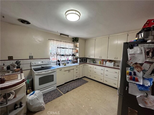 159 S Shasta St S, Willows, CA 95988 - kitchen featuring appliances with stainless steel finishes, tile walls, a sink, white cabinets, and a wainscoted wall