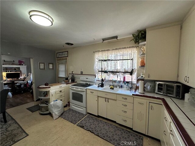 159 S Shasta St S, Willows, CA 95988 - kitchen with white range with electric cooktop, tile countertops, a sink, and cream cabinetry