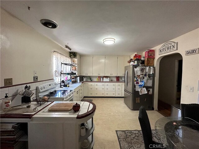 159 S Shasta St S, Willows, CA 95988 - kitchen featuring freestanding refrigerator, electric range, arched walkways, light flooring, and a sink