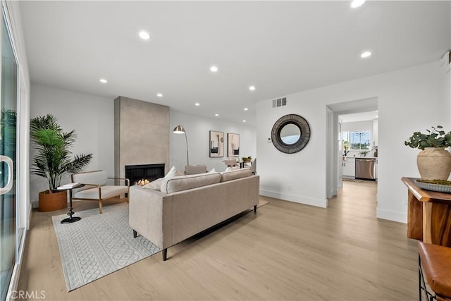 7061 Kester Ave Unit H, Van Nuys, CA 91405 - living area featuring light wood-style floors, a fireplace, recessed lighting, and baseboards