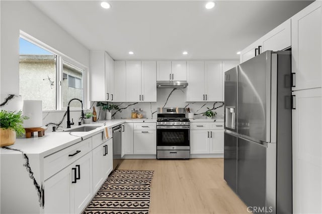 7061 Kester Ave Unit H, Van Nuys, CA 91405 - kitchen with stainless steel appliances, a sink, under cabinet range hood, light countertops, and white cabinetry