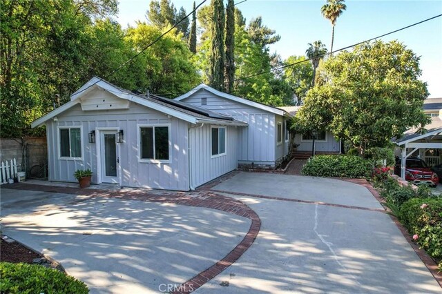 20955 De Mina St, Woodland Hills, CA 91364 - view of front of house featuring board and batten siding and a patio area
