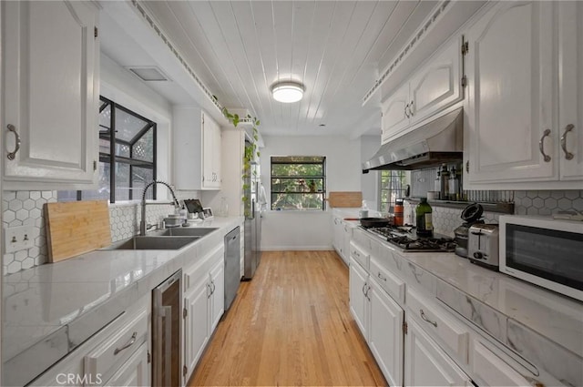 20955 De Mina St, Woodland Hills, CA 91364 - kitchen featuring gas stovetop, under cabinet range hood, a sink, light wood-type flooring, and dishwasher