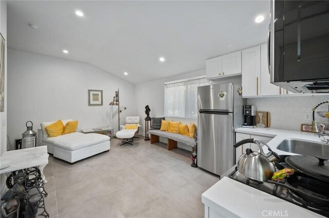 20955 De Mina St, Woodland Hills, CA 91364 - kitchen featuring stainless steel appliances, a sink, light countertops, white cabinets, and lofted ceiling