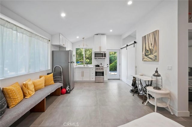 20955 De Mina St, Woodland Hills, CA 91364 - kitchen with stainless steel appliances, a barn door, white cabinetry, recessed lighting, and vaulted ceiling