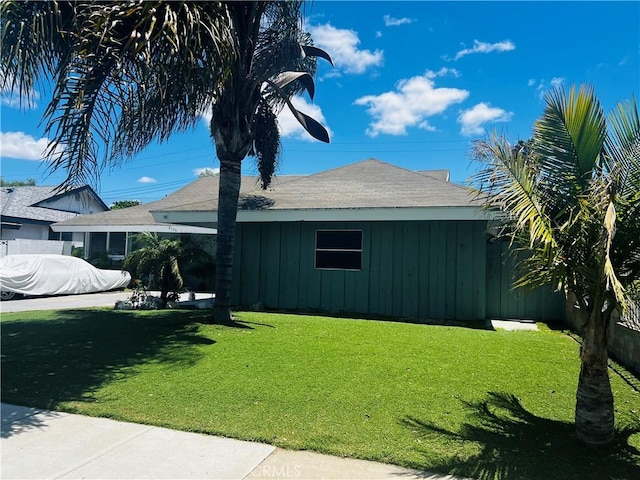 2113 N Lewis St, Santa Ana, CA 92706 - view of side of home featuring board and batten siding, a yard, and a shingled roof