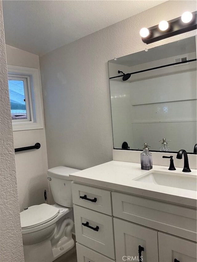 2113 N Lewis St, Santa Ana, CA 92706 - bathroom with toilet, vanity, a textured wall, and a shower