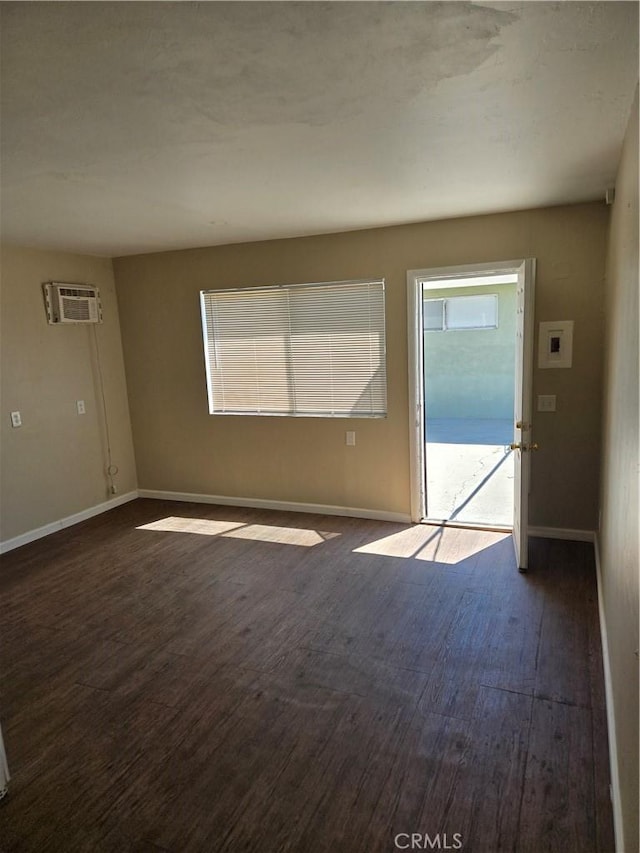 6025 Florence St, Riverside, CA 92504 - spare room featuring a wall unit AC, dark wood-type flooring, and baseboards