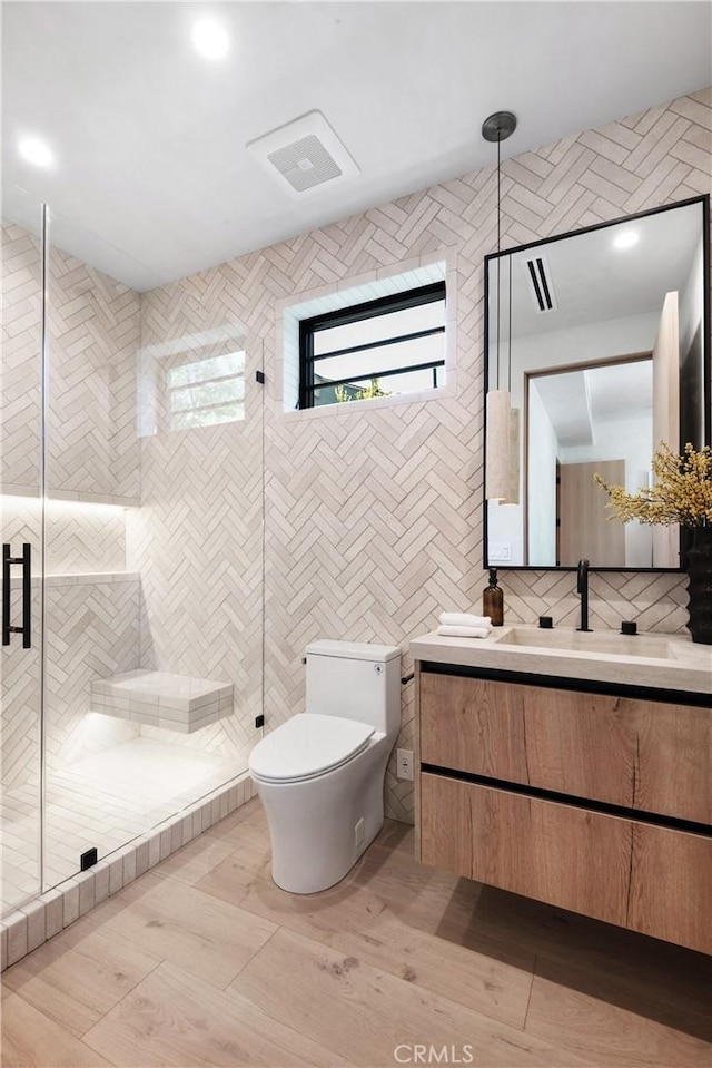 4314 Teesdale Ave, Studio City, CA 91604 - bathroom featuring vanity, toilet, a stall shower, tile walls, and wood finished floors