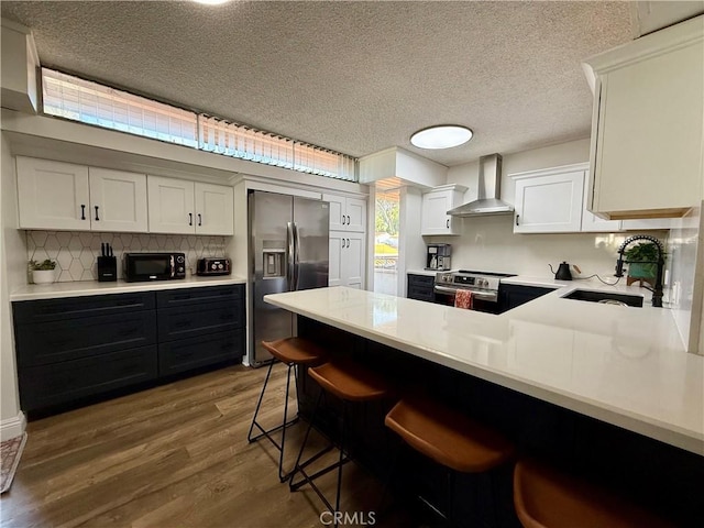 5658 Ravenspur Dr Unit 202, Rancho Palos Verdes, CA 90275 - kitchen with stainless steel appliances, a sink, wall chimney exhaust hood, light countertops, and wood finished floors