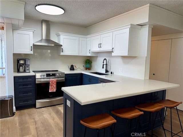 5658 Ravenspur Dr Unit 202, Rancho Palos Verdes, CA 90275 - kitchen featuring stainless steel range with electric cooktop, a sink, wall chimney exhaust hood, a peninsula, and a breakfast bar