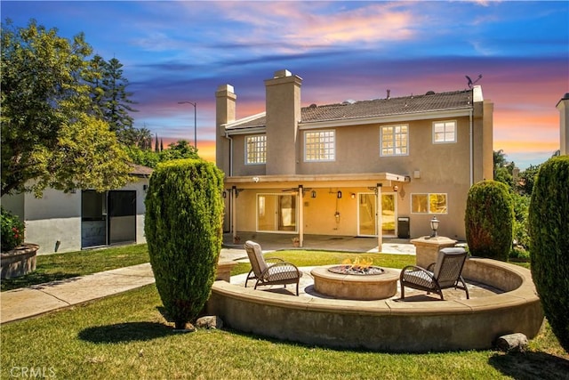 9455 Brandon Ct, Northridge, CA 91325 - back of house featuring a fire pit, a patio, stucco siding, a yard, and a chimney