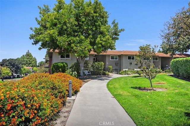2117 Via Puerta Unit A, Laguna Woods, CA 92637 - view of front of house with a front yard, stucco siding, and a tiled roof
