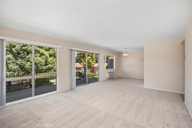 2117 Via Puerta Unit A, Laguna Woods, CA 92637 - empty room with light carpet, a ceiling fan, a wall mounted AC, and baseboards