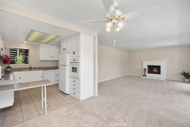 2117 Via Puerta Unit A, Laguna Woods, CA 92637 - kitchen with white appliances, light carpet, a sink, white cabinetry, and a ceiling fan