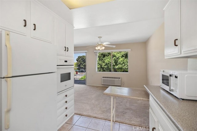 2117 Via Puerta Unit A, Laguna Woods, CA 92637 - kitchen featuring white appliances, light colored carpet, a wall mounted air conditioner, light tile patterned floors, and ceiling fan
