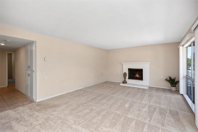 2117 Via Puerta Unit A, Laguna Woods, CA 92637 - unfurnished living room featuring light colored carpet, a brick fireplace, and baseboards