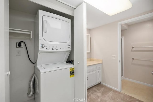 2117 Via Puerta Unit A, Laguna Woods, CA 92637 - laundry room featuring estacked washer and dryer, light colored carpet, and baseboards