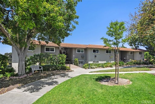 2117 Via Puerta Unit A, Laguna Woods, CA 92637 - view of front of house featuring a front yard, a tile roof, and stucco siding