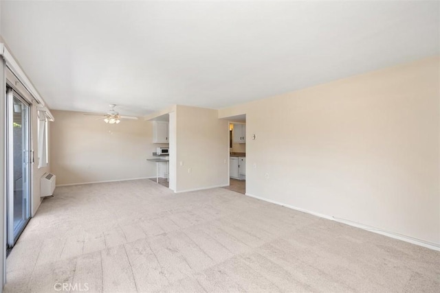 2117 Via Puerta Unit A, Laguna Woods, CA 92637 - unfurnished living room with light colored carpet, baseboards, and ceiling fan