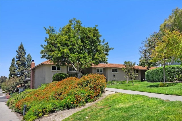 2117 Via Puerta Unit A, Laguna Woods, CA 92637 - view of front of home with a front yard, stucco siding, and a tiled roof