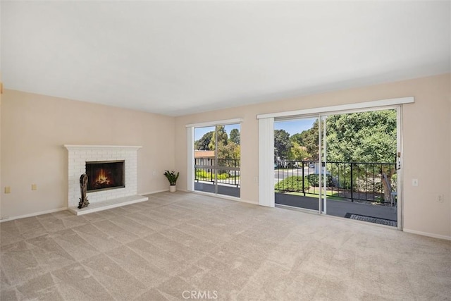 2117 Via Puerta Unit A, Laguna Woods, CA 92637 - unfurnished living room featuring light colored carpet, a brick fireplace, and baseboards